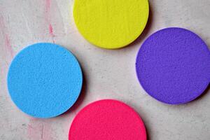 Colorful sponges on textured desk. Bright abstract background. photo