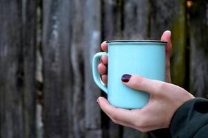 A mug of tea in cold weather. A cup of tea in woman's hands. photo