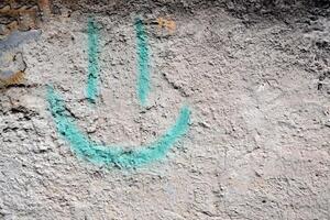 sonrisa pintado en el cemento pared. cemento antecedentes foto