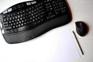 Black keyboard, mouse white pencil and pen on the white table. photo