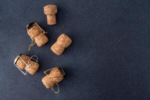 Champagne corks and metal mesh. Dark wine background photo