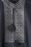 Ukrainian clothes embroidered man shirt. Blue gray and black threads background. Vyshyvanka is a symbol of Ukraine. Embroidery cross stitching. National Ukrainian stitch. Traditional clothing symbol photo