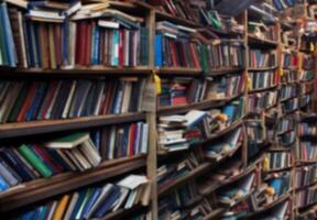 Book background. Selective focus. Blurred texture of old books. Bookshelves in the library photo