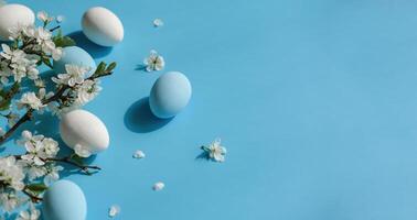 pastel azul y blanco huevos con Cereza flores en un azul antecedentes simbolizando primavera y Pascua de Resurrección. bandera con Copiar espacio foto