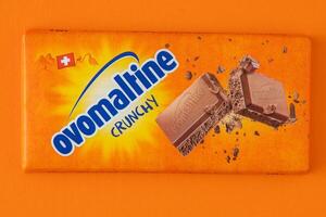 Swiss chocolate from Ovomaltine. Tiles in orange packaging. Sweetness. Milk chocolate 100 grams. Kyiv, Ukraine - June 19, 2023 photo