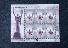 A block of Ukrainian postage stamps. Ukraine - Mother. Statue with sword and coat of arms. Ukraine, Kyiv - December 31, 2023 photo