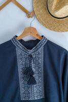 Ukrainian clothes embroidered man shirt. Blue gray and black threads background. Vyshyvanka is a symbol of Ukraine. Embroidery cross stitching. National Ukrainian stitch. Traditional clothing symbol photo