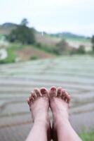 Woman feet selfie is traveler relaxing with rice terrace and mountains view photo
