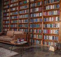 Knowledge and education. Reading hobby. A place for learning and cozy solitude and relaxation. Books on a shelf in an empty library. photo