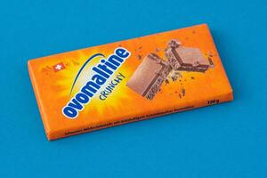 Swiss chocolate from Ovomaltine. Tiles in orange packaging. Sweetness. Milk chocolate 100 grams. Kyiv, Ukraine - June 19, 2023 photo