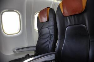 un asiento en el avión. vacío cabina de el avión. suave asientos para pasajeros, ojos de buey dentro un pasajero avión foto