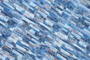 Pattern element of the external facade of a stone wall made of gray and blue brick, tile elements. Abstract background. photo