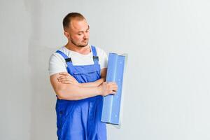 A man processes the wall with a spatula. Plasterer at work. photo