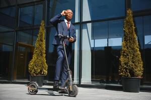 joven africano empresario montando un eléctrico scooter foto