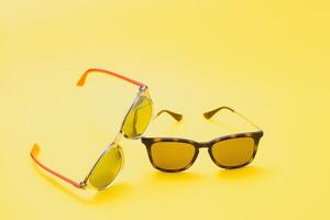 Brown glasses on yellow background photo
