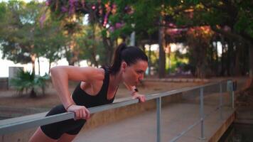 a woman is doing push ups on a railing video