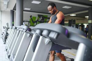 Man running on treadmill in gym photo