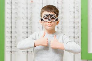 Boy put trial frame at clinic Medical Optician concept photo