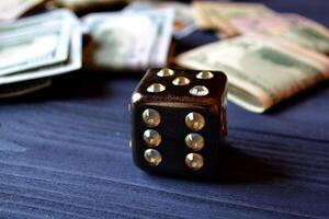 Dice cube with precious jewels on the table and money. Plaing cube. Games of chance. photo