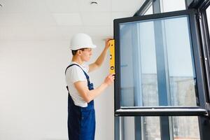 trabajador de la construcción instalando ventana en casa foto