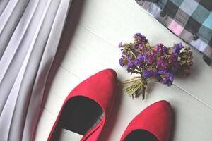 Casual cloth and bouquet of flower on the white wooden table. photo