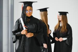 portrait of multiracial graduates holding diploma photo