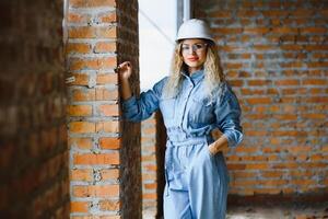 joven mujer trabajador con un blanco casco en el construcción sitio. foto