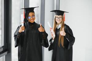 portrait of multiracial graduates holding diploma photo