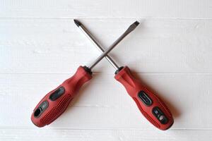 Red screwdrivers isolated on the white wooden background. photo