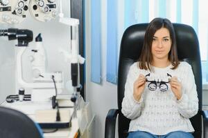 selección de lentes para visión para el mujer. el correcto selección de puntos. óptico salón. óptico. juicio lentes foto