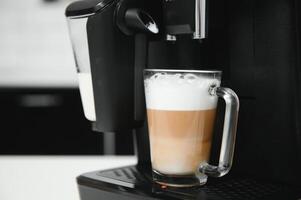 Modern coffee machine on table in kitchen photo