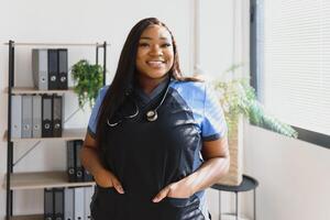 Young beautiful African American girl doctor in a white coat with a stethoscope. photo