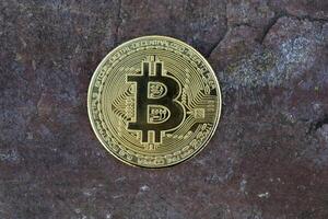 Golden bitcoin on stone background. photo