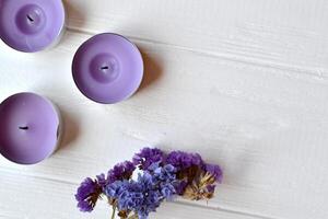 Letter, glasses, candle and flower on the white table. Beutiful female objects on the white wooden background. Flat lay in violet color. photo