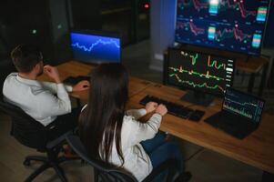 equipo de comerciantes trabajando a monitor computadora y hojeada en línea en comercio oficina foto