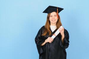 Beautiful woman wearing graduation cap and ceremony robe holding degree looking positive and happy standing and smiling with a confident smile. photo