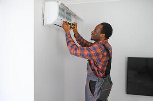 profesional reparador instalando aire acondicionador en un habitación foto