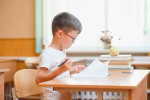 School boy in classroom at lesson photo