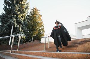 Portrait of a confident and joyful young graduate with a diploma. Man is ready for the next step in his life. photo