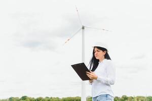 Environmental engineer with a laptop at wind farm photo