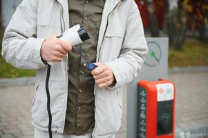 Man charging his electric car. photo