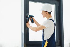 Construction worker installing window in house photo