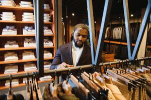 A stylish elegantly dressed African-American man working at classic menswear store. photo