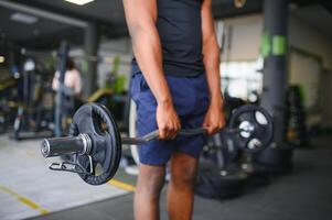 Portrait Of Athletic Man With Barbell In Hands Exercising At Gym photo