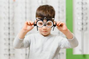 child boy showing trial frame in ophthalmology clinic, selective focus. photo