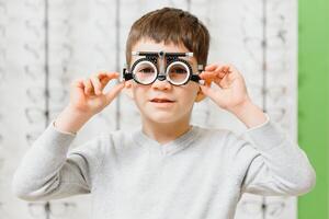 Boy put trial frame at clinic Medical Optician concept photo