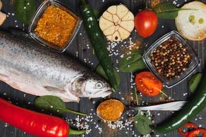 fresh trout with spices and seasonings top view, flat lay photo