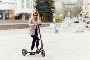 niña en eléctrico scooter montando en el antiguo ciudad centrar foto