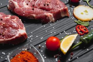 raw meat with fresh vegetables and spices on wooden background. Top view. Free space for text. prepare yourself concept. photo