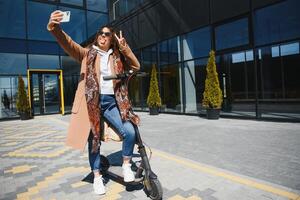 Young woman with electric scooter at the city photo